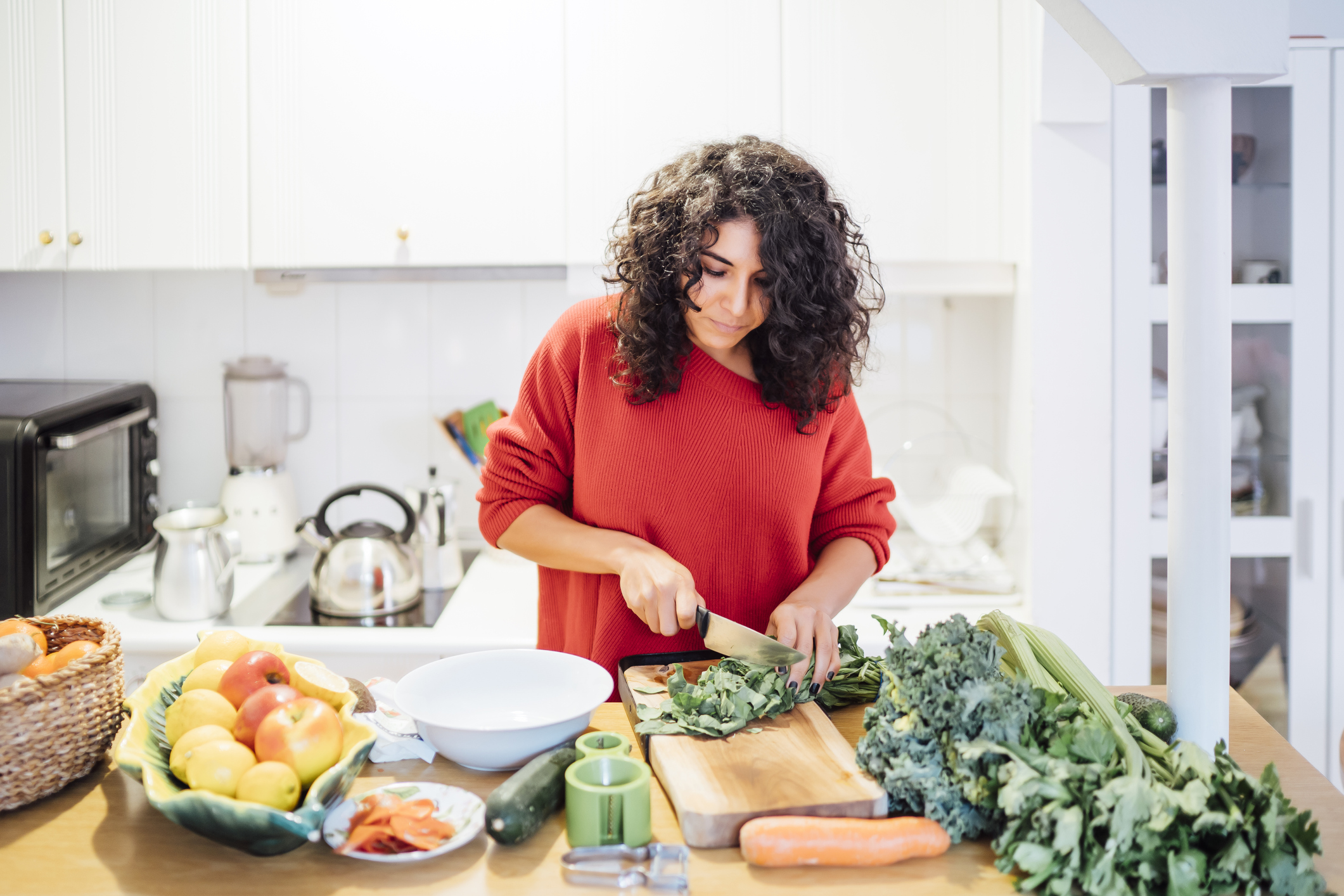 浅黑肤色的女人正在做健康的蔬菜沙拉。