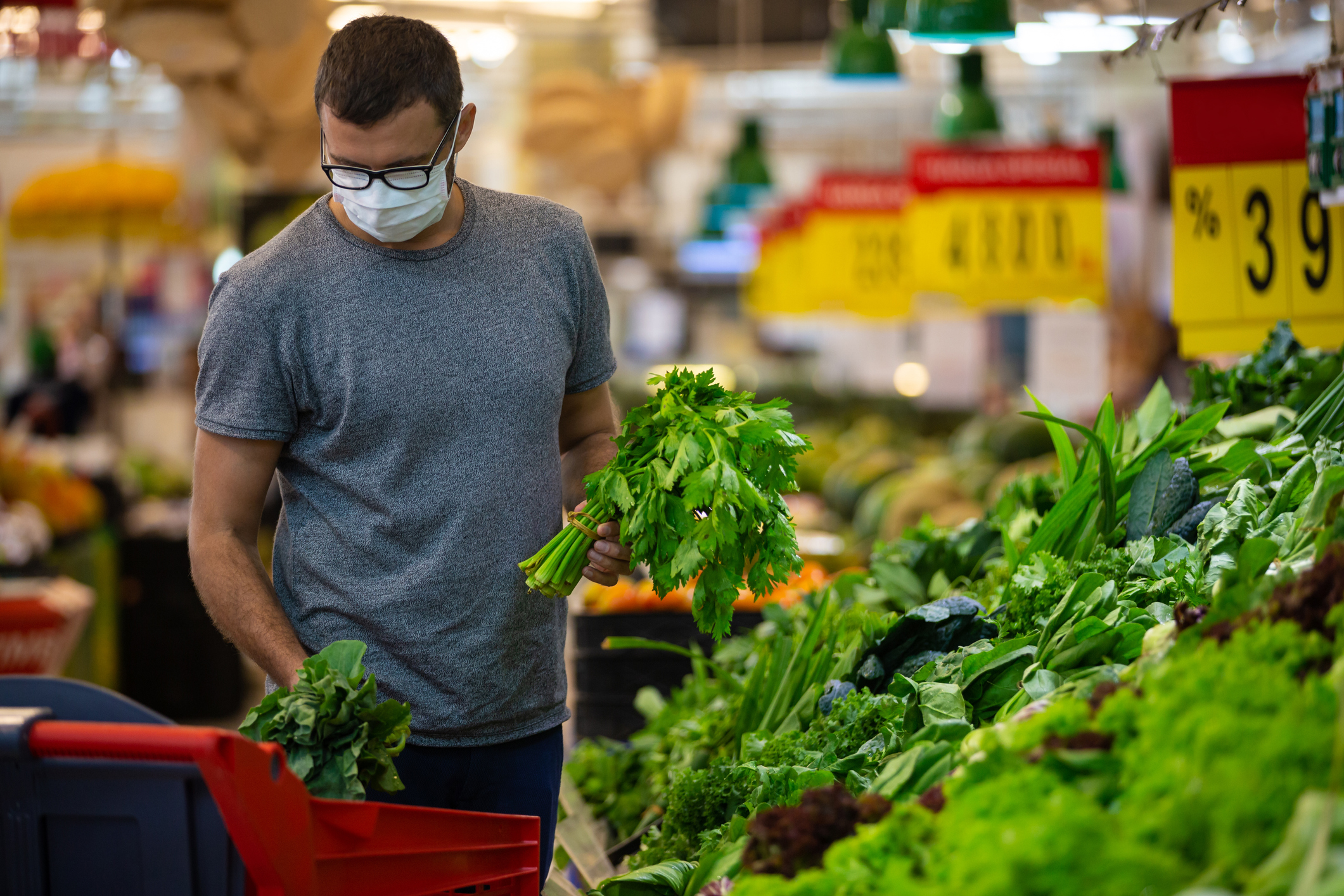 神色紧张的男子在超市或商店购买杂货时戴着可抵御冠状病毒的口罩 - 健康、安全和大流行的概念 - 为防止 covid-19病毒传播而戴上防护性口罩的年轻人正在堆存食物