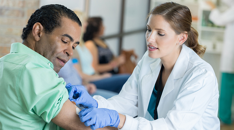 医疗保健专业人员为一名患者提供预防性疫苗接种。