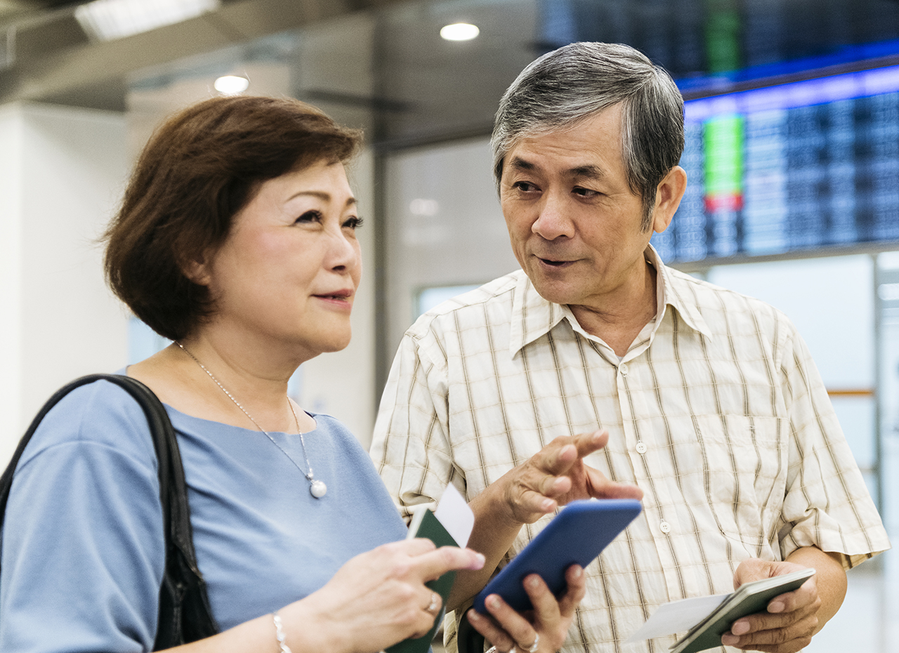 机场里活跃的老年人在旅行时使用手机应用程序管理糖尿病
